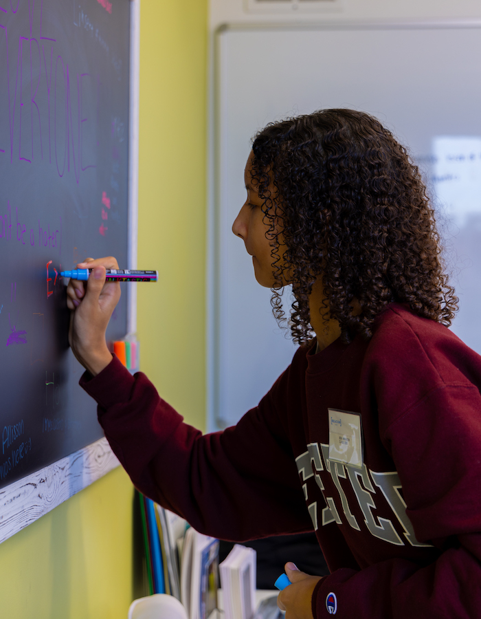 Beacon Academy student writing on board